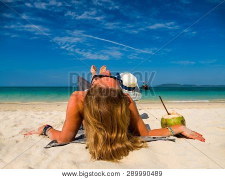 Woman enjoying her holidays on a transat at the tropical beach in Thailand