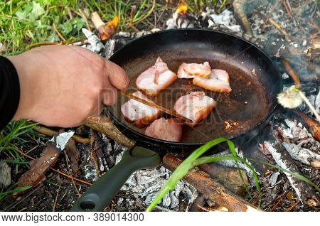 Outdoor Cooking In A Frying Pan By A Mans Hand With A Spatula. Bbq. Stock Photo