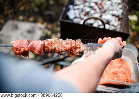 A Man Prepares A Shish Kebab, Close-up. Juicy Grilled Meat On A Skewer