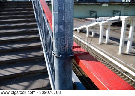Iron Fastening Of A Street Pillar In The Stair Railings, Close-up. Metal Connection In The Form Of A