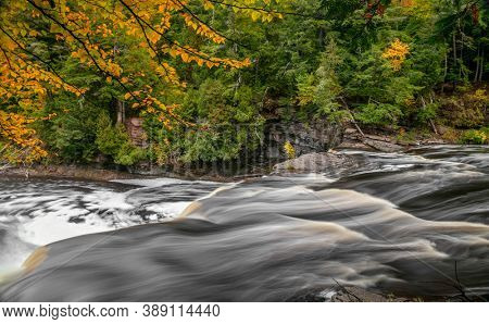 Running water at Manido falls in Michigan upper peninsula during autumn time.