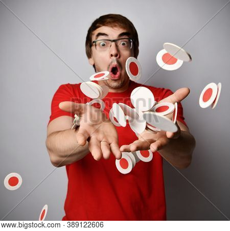 Shocked Man In Red T-shirt And Glasses Trows Tosses Amount Of Round White With Red Beermats Cardboar
