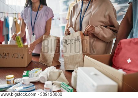 Cropped Shot Of Group Of Volunteers Packing Medicine Donation In Paper Bags And Boxes For Needy Peop
