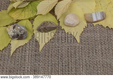 Four Semi-precious Stones Of Septaria, Landscape Jasper, Yellow Quartz, Agate Lie On Jute Fabric On 