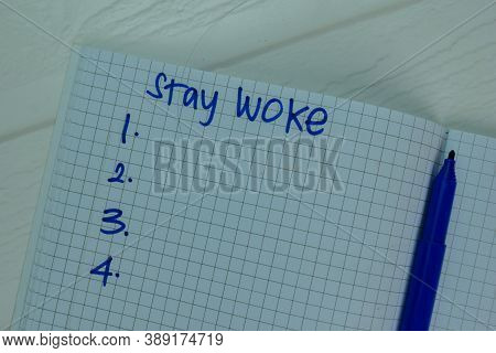 Stay Woke Write On A Book Supported By An Additional Services Isolated On Office Desk.