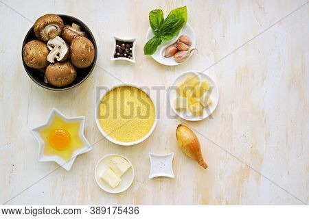 Prepared Ingredients For Cooking Polenta With Fried Mushrooms And An Egg On A Light Concrete Backgro