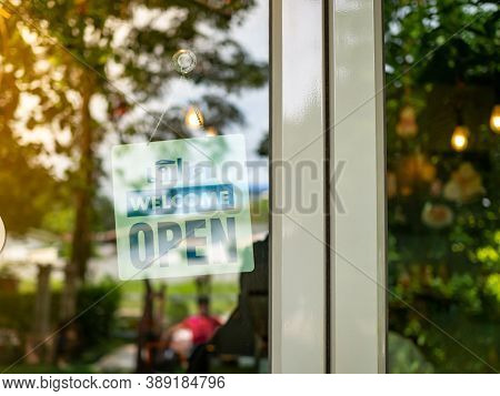 An Open Sign Hangs Behind The Glass Of A Shop Door. The Idea Of Starting A Business. Busisness Conce