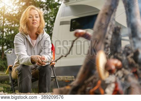 Camping Caucasian Woman In Her 40s Grilling Polish Sausage Directly On Fire In Front Of Her Rv Recre