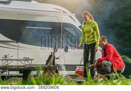 Recreational Vehicle Rv Park Pitch And Caucasian Couple Making Campfire And Grilling Some Food Havin