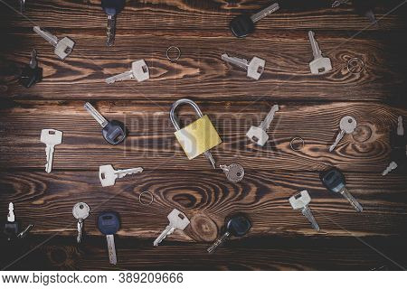 Studio Photo Of A Lock With A Broken Key In It On A Wooden Background. Lots Of Other New Keys Around