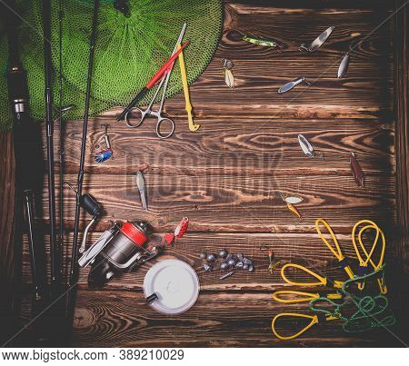 Fishing Tackle On A Wooden Background. Studio Photo With Vignetting.