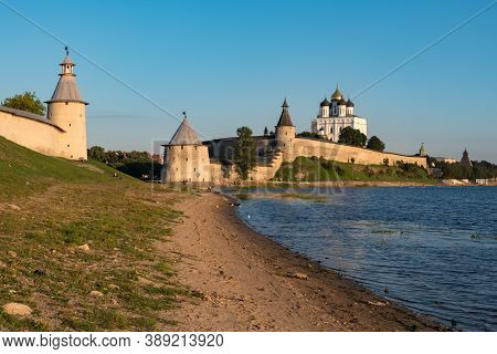 Pskov Kremlin View From River Pskova Creek. Towers, Wall And Trinity Cathedral On Background.