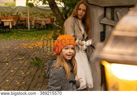 Halloween Autumn Kids. Portrait Magic Girl In Coat, Hat With Street Lantern In Park. Photo