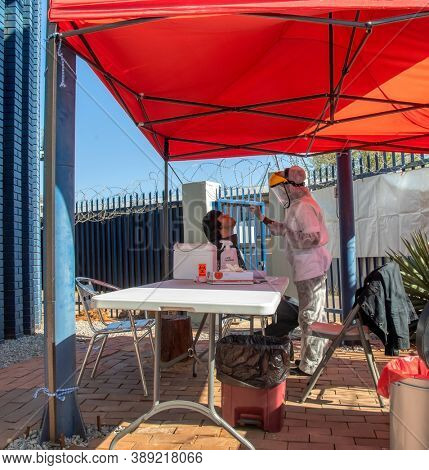 African mobile lab for covid testing in the yard, Caucasian patient getting tested