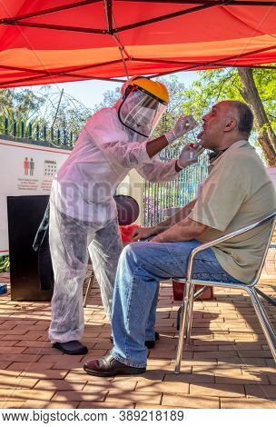 African mobile lab for covid testing in the yard, Caucasian patient getting tested
