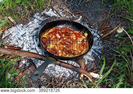 Cooking Dinner On Campfire In Cast Iron Pan. Bbq Stock Photo