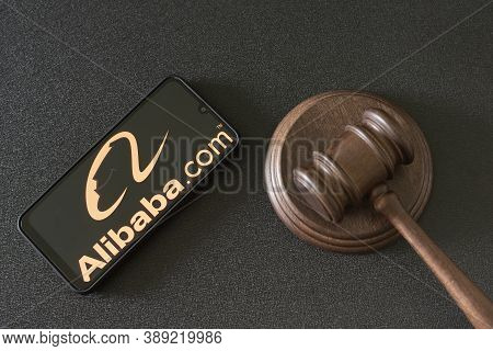 Kharkov, Ukraine - June 25, 2020: Alibaba.com Logo On Phone Display Next To Judges Gavel. Alibaba Is