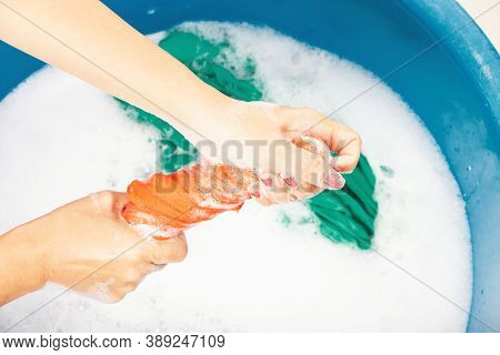 Closeup Young Asian Woman Use Hands Washing Color Clothes In Basin. Female Squeeze Wring Out Wet Fab