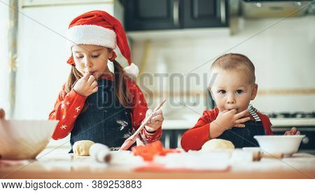 Caucasian Brother And Sister Preparing Food For The Christmas Holidays Wearing Santa Clothes In The 