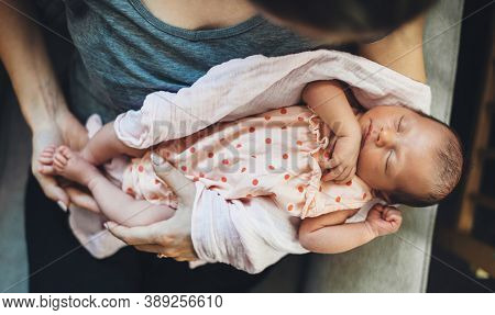 Caucasian Woman Holding His Newbord Daughter Sleeping In Her Hands In A Nice Dress
