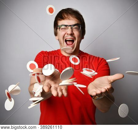 Laughing Adult Man In Red T-shirt And Glasses Has Fun Trowing Tossing  Trying To Juggle Round White 