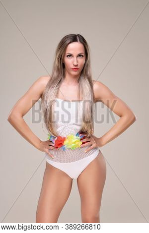 Beautiful Slim And Fit Girl With Long Blond Hair In Whiteswimsuit. Glowing Skin