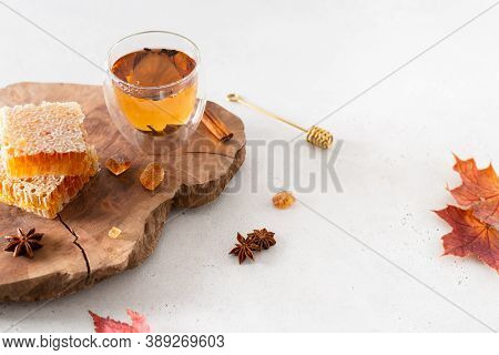 Strengthening Immunity In Autumn. Hot Tea In A Glass Cup, Honey Combs And Spieces On A Wooden Tray O