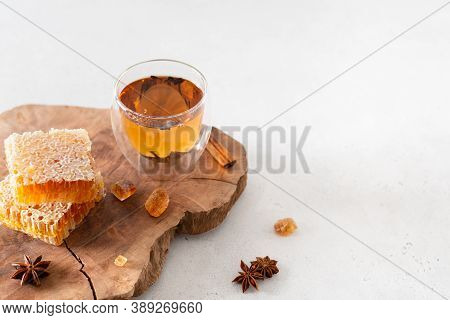 Strengthening Immunity In Autumn. Hot Tea In A Glass Cup, Honey Combs And Spieces On A Wooden Tray O