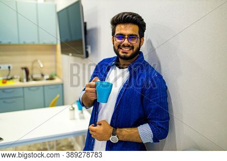 Arabian Man In Casual Dress Holning A Blue Cup And Looking Dreamly