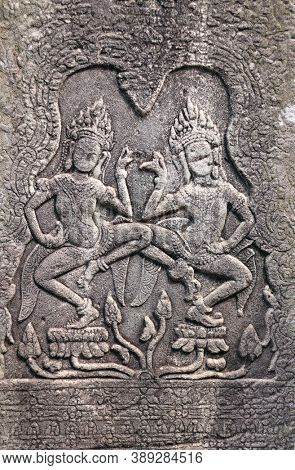 Wall carving with two womans dancers apsara, famous Angkor Wat complex, Siem Reap, Cambodia. Vertical background with bas-relief with dancing girls. Mock up template. Copy space for text