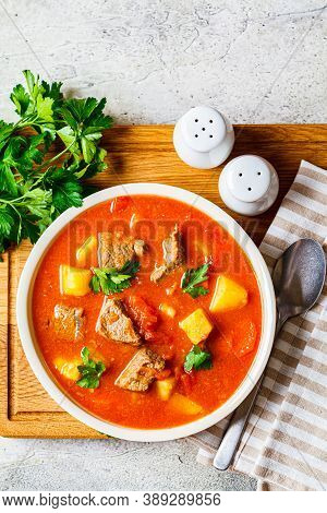 Soup With Beef And Vegetables In A White Plate On A Wooden Board. Traditional Meat Shurpa Soup With 