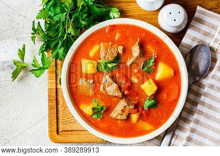 Soup With Beef And Vegetables In A White Plate On A Wooden Board. Traditional Meat Shurpa Soup With 