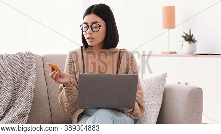 Online Banking And E-commerce Concept. Asian Woman In Glasses Making Purchases On Internet, Using La
