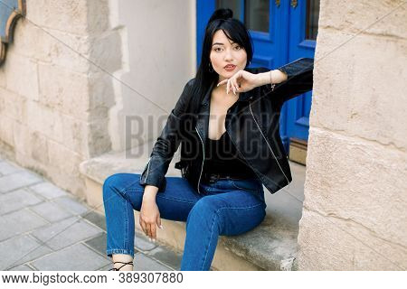 Smiling And Sensual Young Mixed Raced Brunette Woman, Wearing Denim Jeans And Black Leather Jacker, 