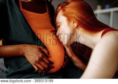 Cheerful Afro And European Lesbian Women At Home On The Bed