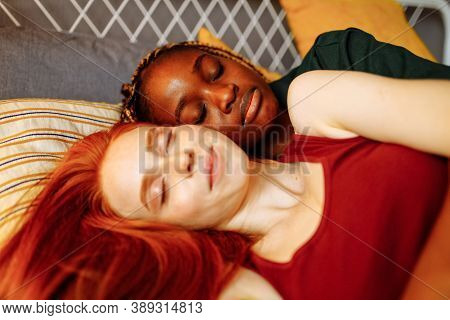 Cheerful Afro And European Lesbian Women At Home On The Bed
