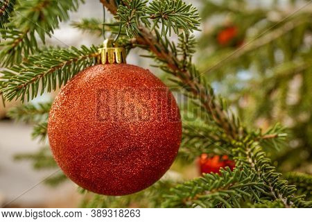 Red toy balls for the decoration of the spruce in the celebration of Christmas