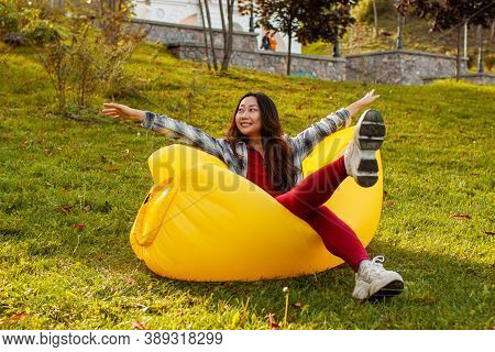 Young Woman Resting On An Air Sofa In The Park.