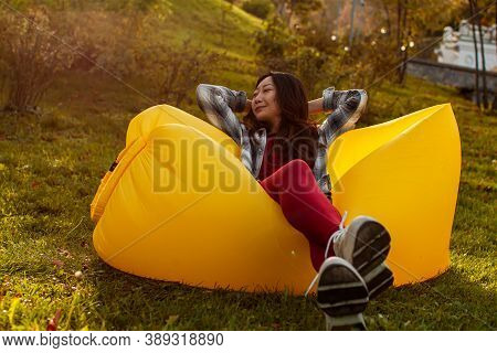 Young Woman Resting On An Air Sofa In The Park.