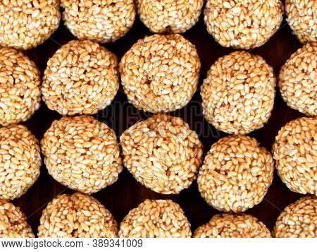 White Sesame Seed Balls Made With Heated Jiggery Against Wooden Background