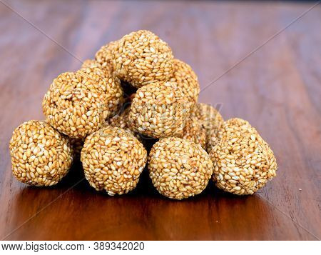 White Sesame Seed Balls Made With Heated Jiggery Against Wooden Background