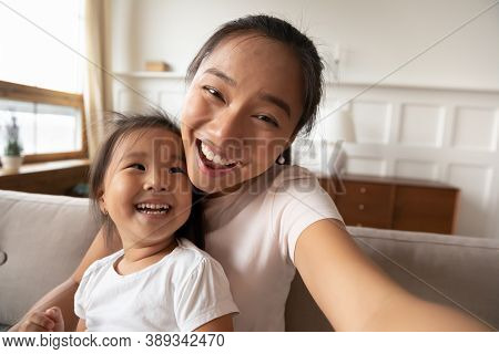Close Up Smiling Asian Mother And Little Girl Taking Selfie