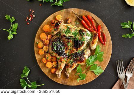 Spatchcocked Grilled Chicken With Vegetables On Plate On A Over Black Stone Background. Top View, Fl