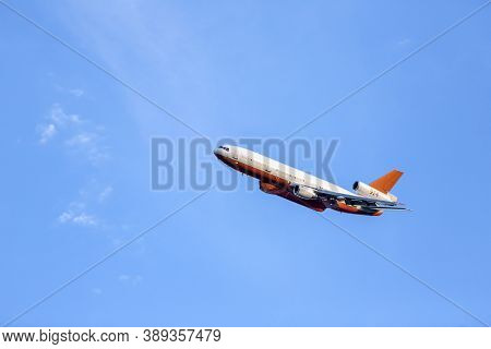 Fire Tanker 914 Flies Through The Blue Sky Tilting Upwards While Turning