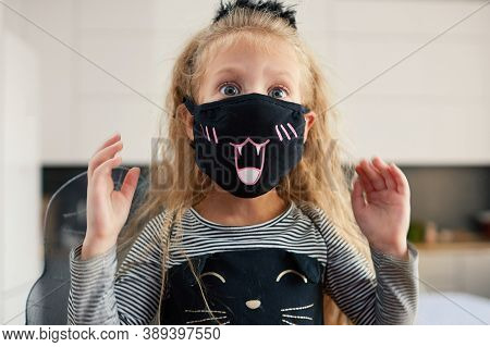 Funny Child Girl Dressed In Witch Canival Costume. Halloween Holiday During Quarantine Time