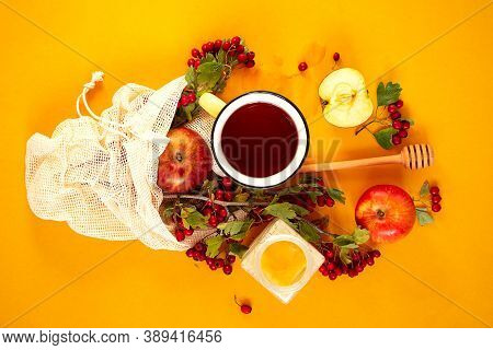 Red Garden Organic Apples, Hawthorn Berries In A Mesh Bag And Cup Of Hot Tea On An Orange Background