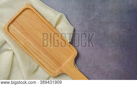 Wooden Bread Cutting Board Blank And Sackcloth Napkin On Polished Cement Background. Top View.