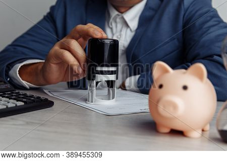 Businessman Approves Important Contract. Piggy Bank With Stack Of Coins On Desk Close-up. Economy, B