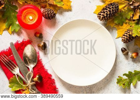 Thanksgiving Food Concept. Autumn Table Setting With Craft Plate, Silverware And Fall Decorations At