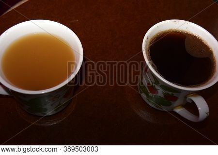 A Cup Of Coffee On A Table, And A Cup Of Juice